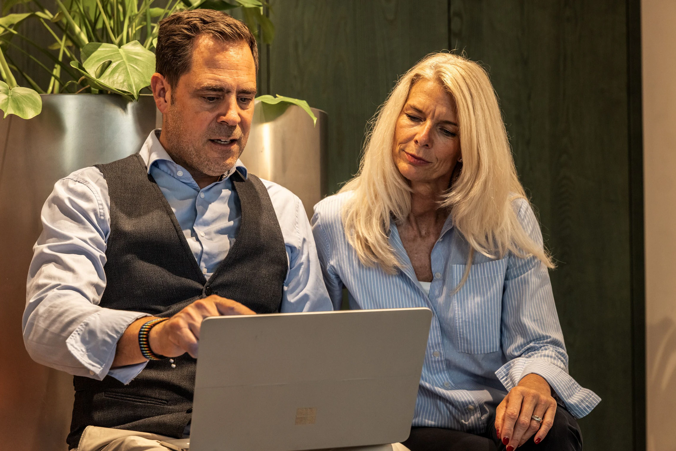 Zwei Personen schauen gemeinsam auf einen Laptop