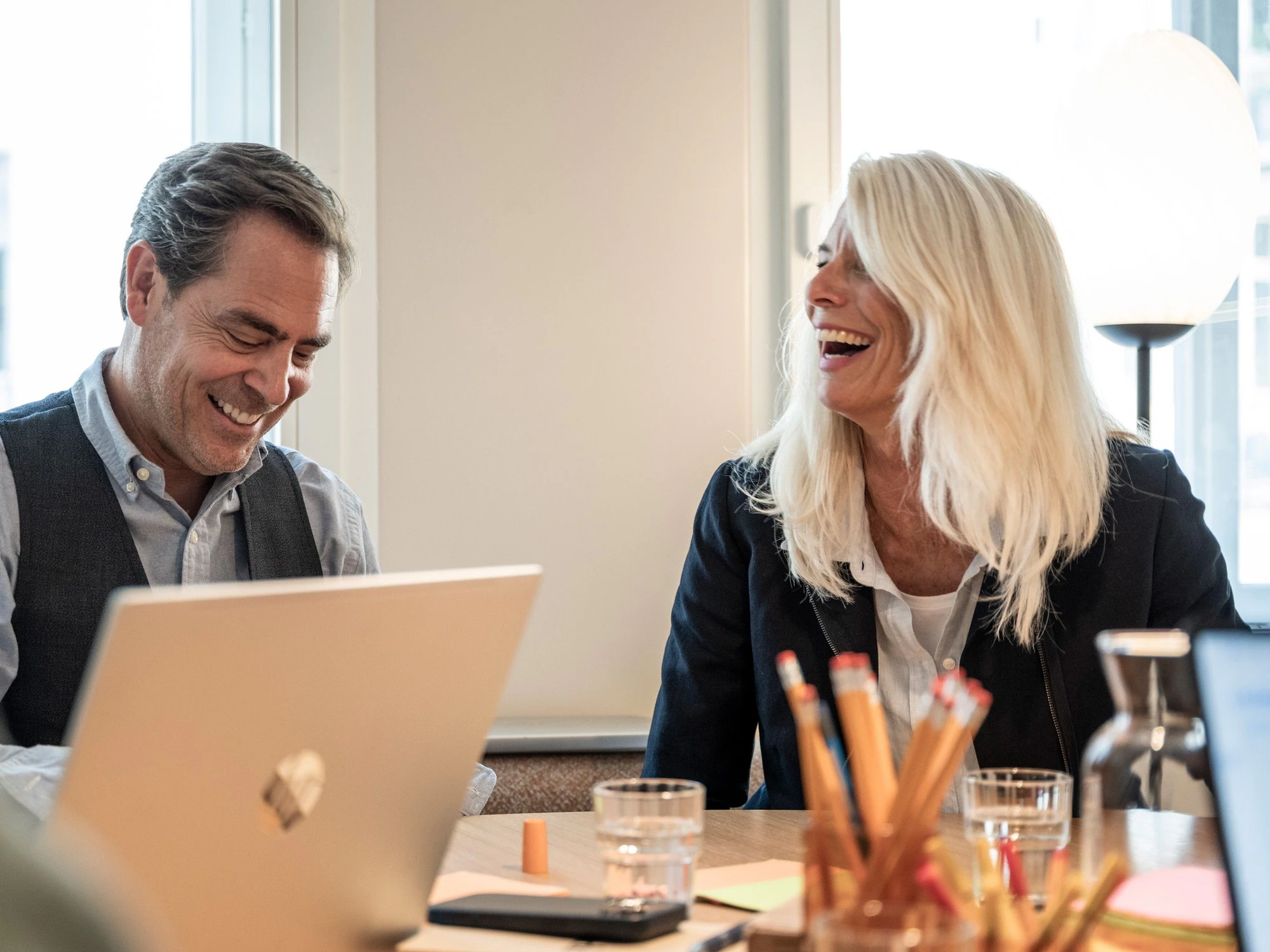 Marc Pfyffer und Kerstin Rufer lachen gemeinsam in einer Besprechung