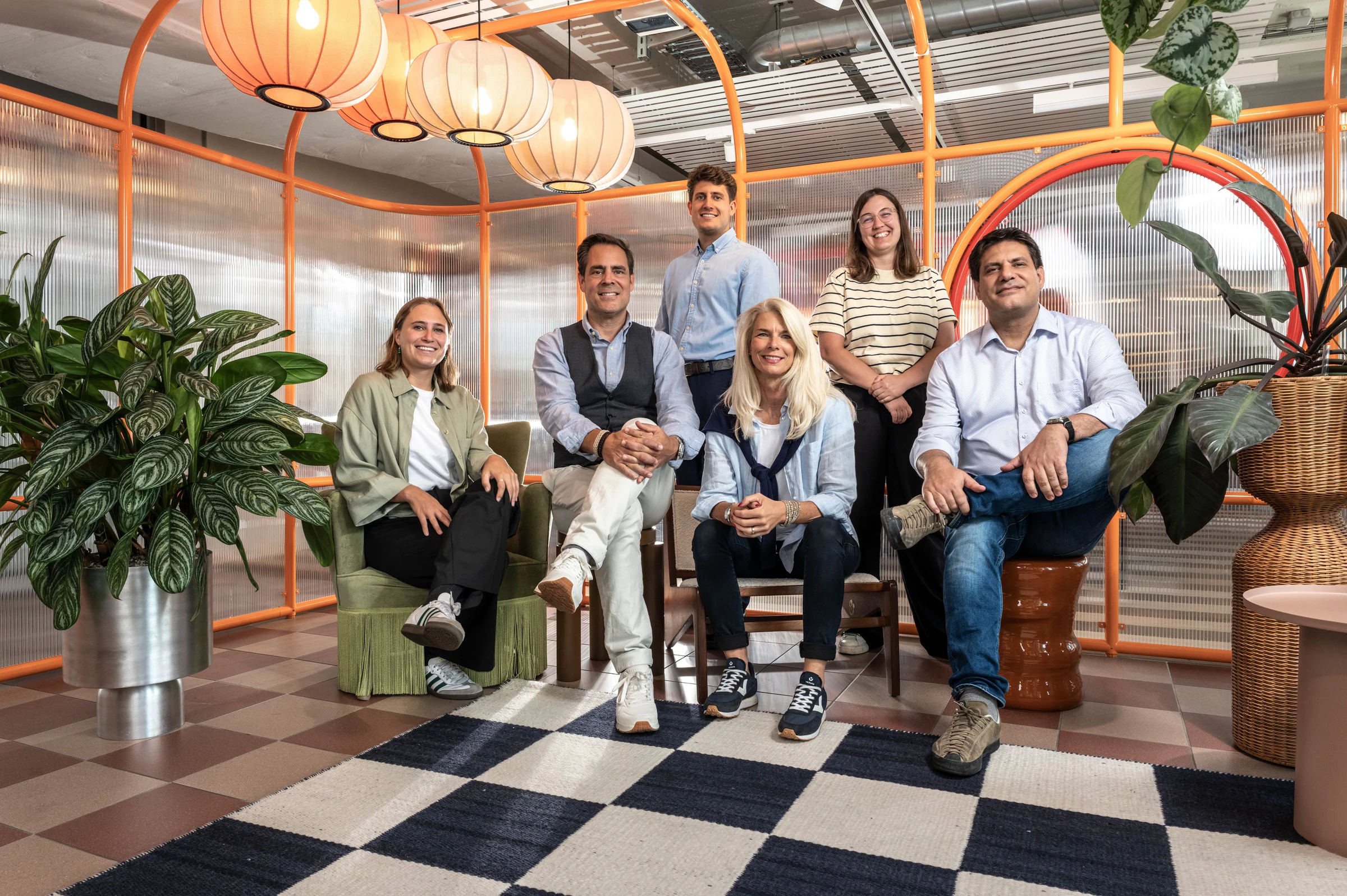 Das Team von Pfyffer Partner, sechs Personen lachend in einer Lounge mit orangefarbenen Lampions